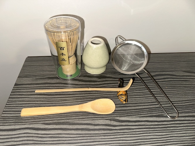 A matcha set including a whisk, whisk holder, bamboo scoop, wooden spoon, and sifter