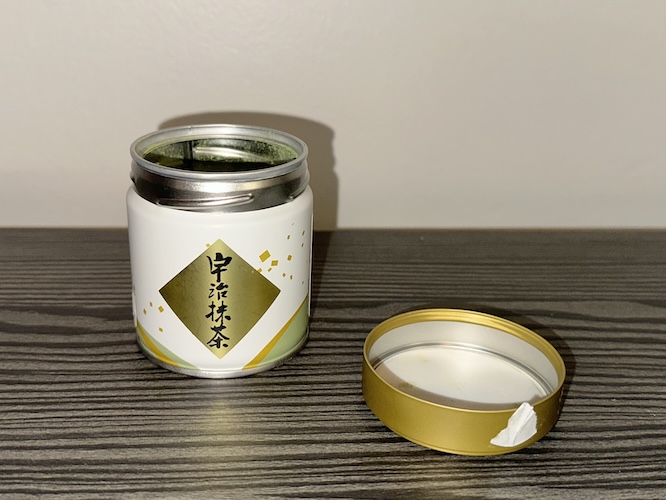 A picture of a container of matcha with the lid off.